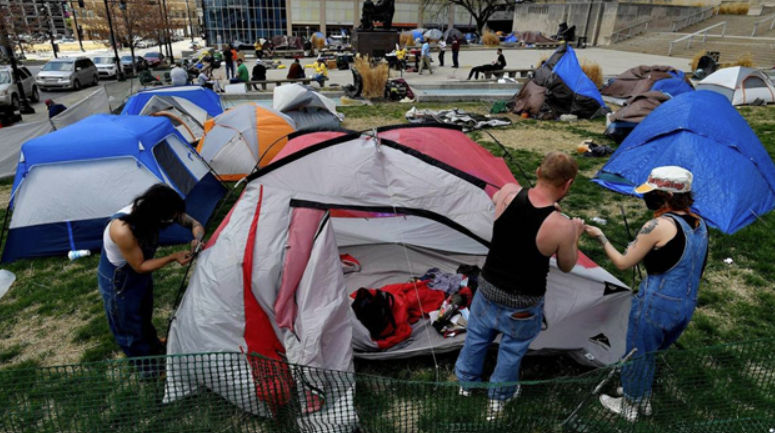 A large tent encampment near a civic building in Kansas City